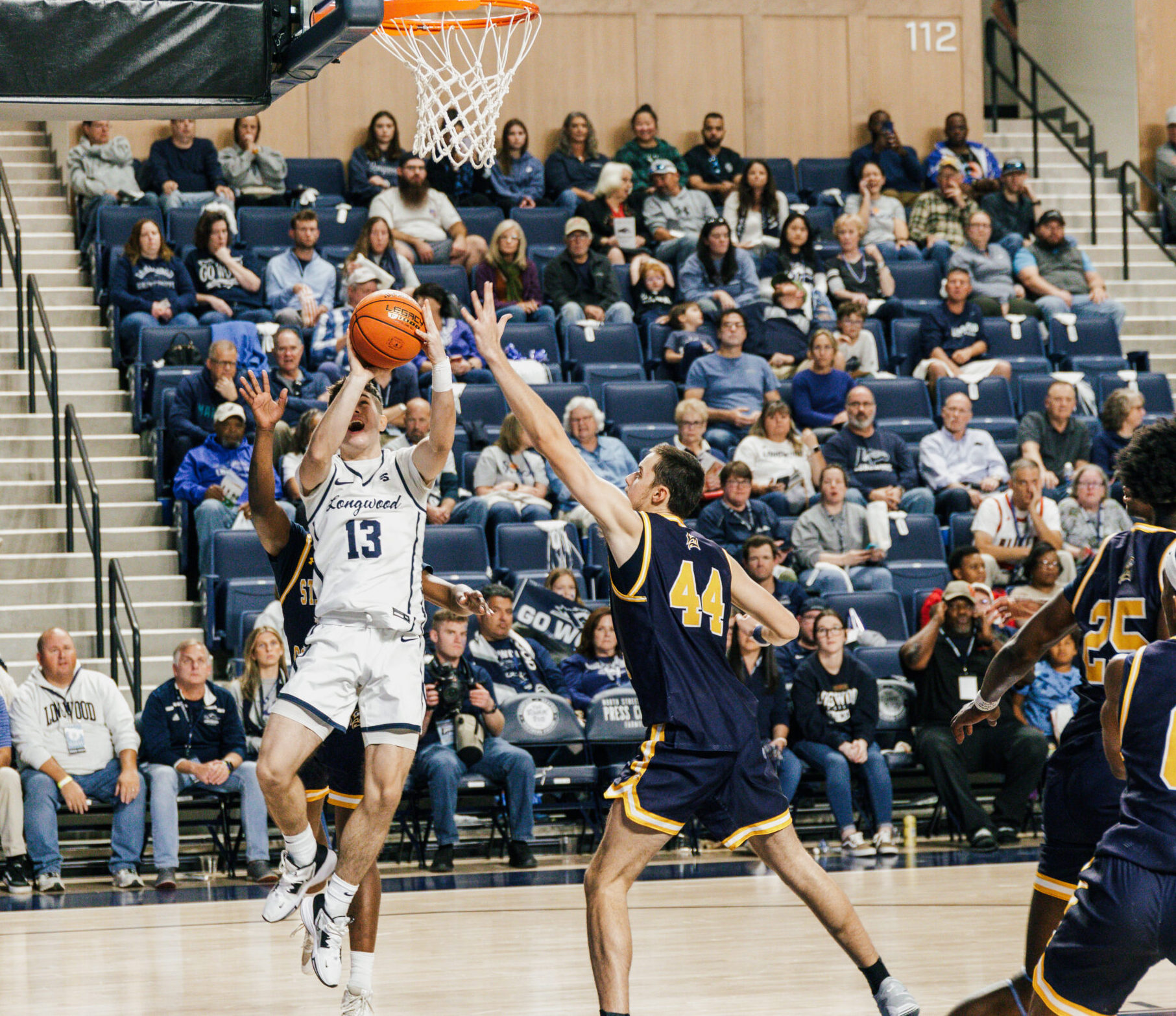 college basketball player going for a layup against opposing team players